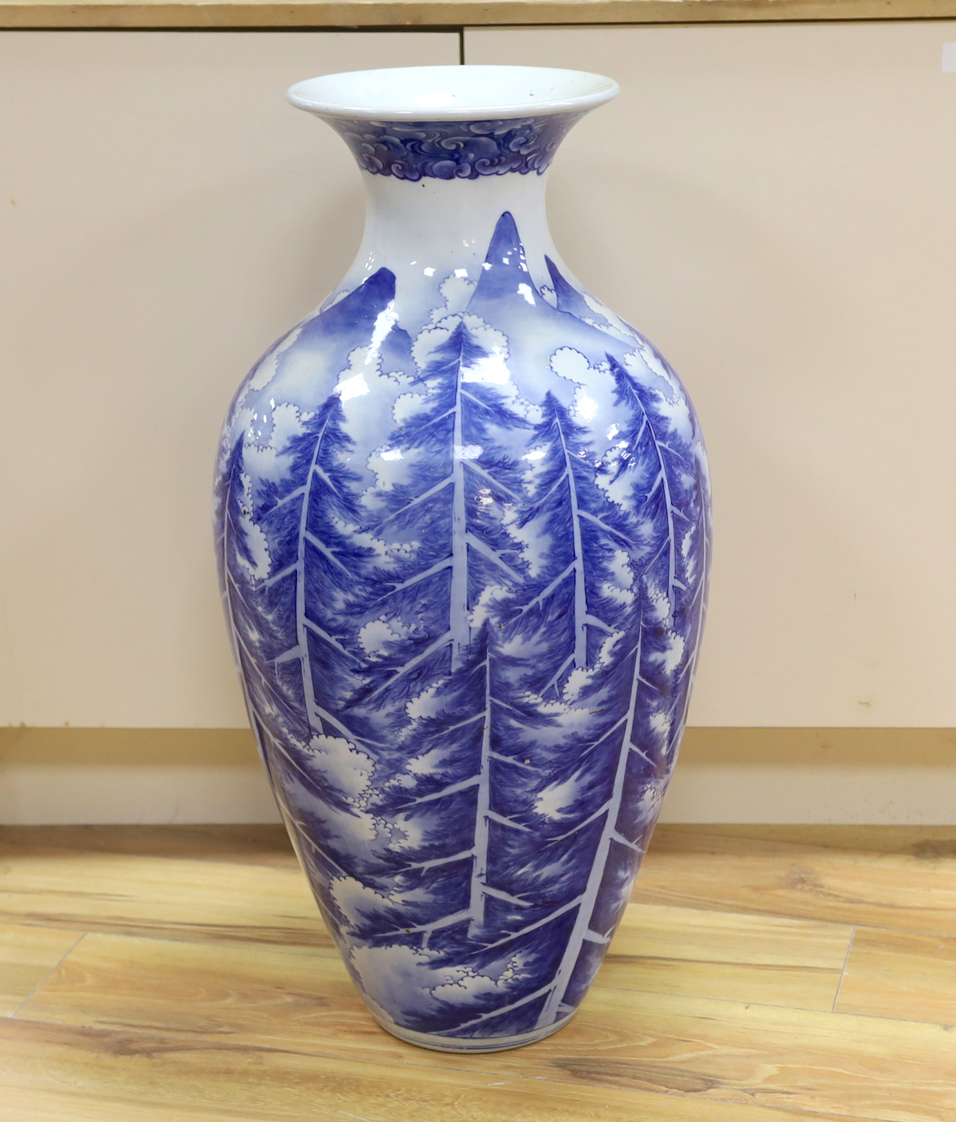 A large Japanese Arita blue and white vase, late 19th century, decorated with pine trees and mountains, 79cm high